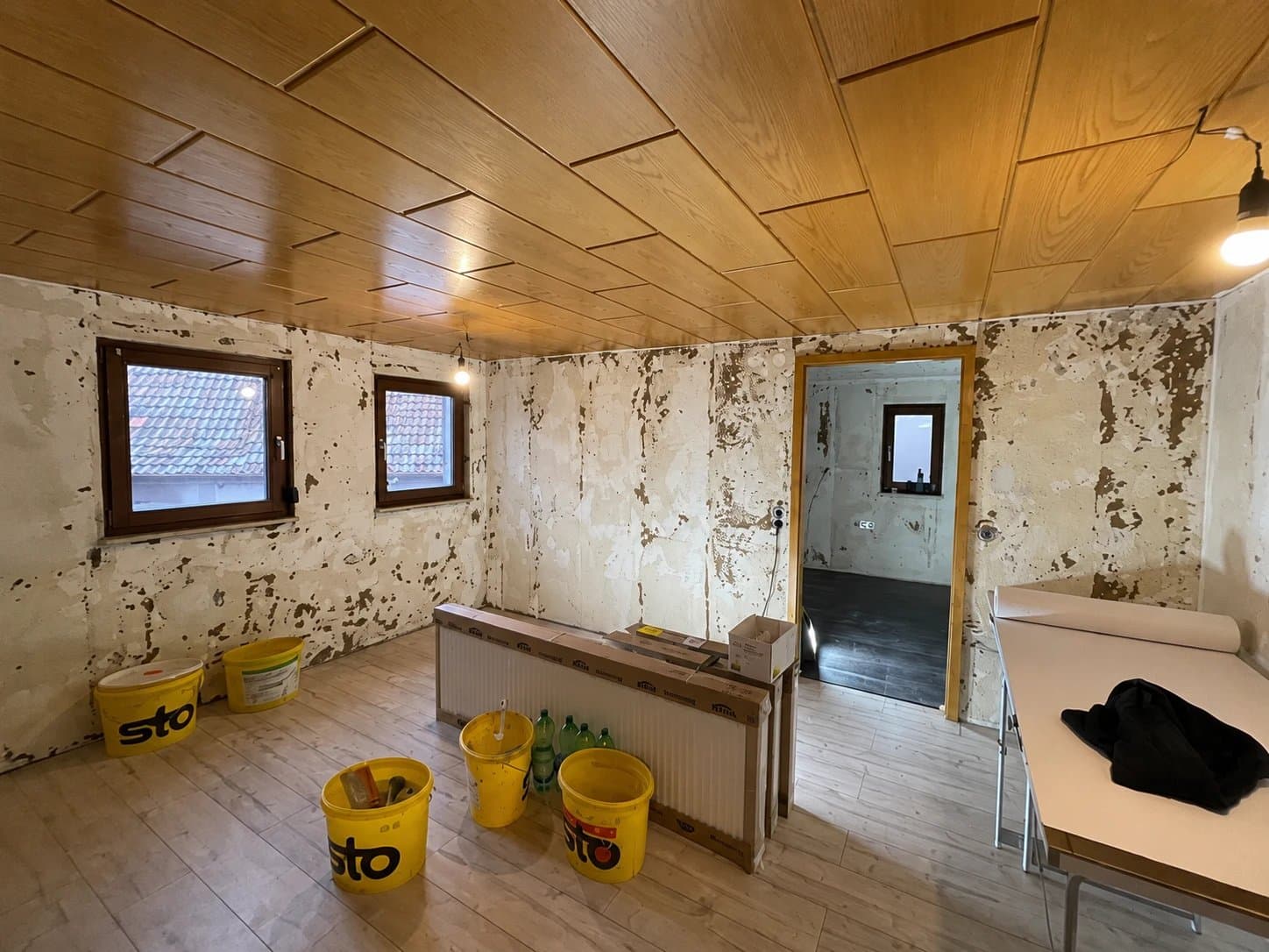 Zimmer mit abgeplatzter Wandfarbe vor der Renovierung