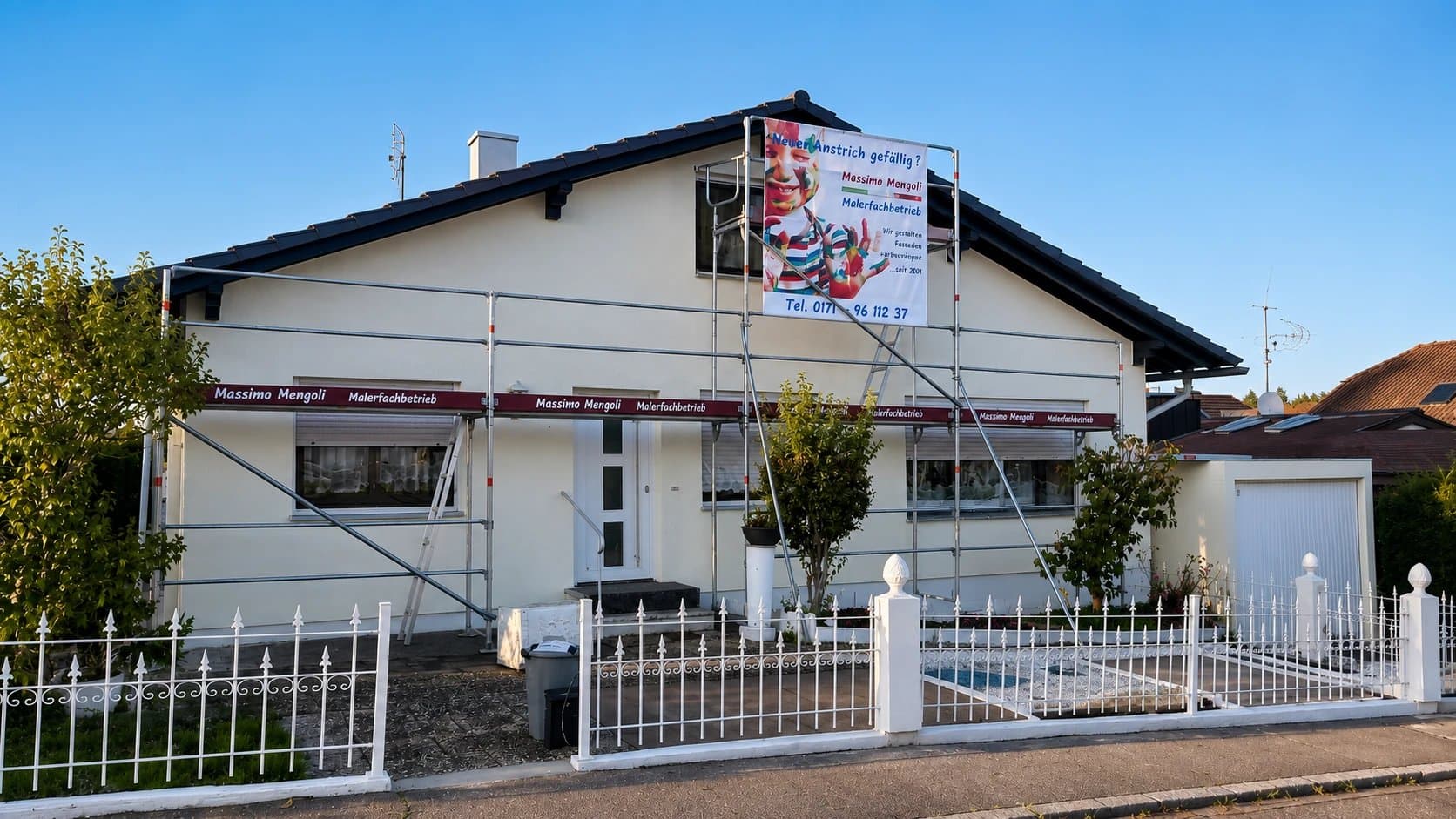 Bungalow mit Gerüst im Abendlicht während der Fassadengestaltung
