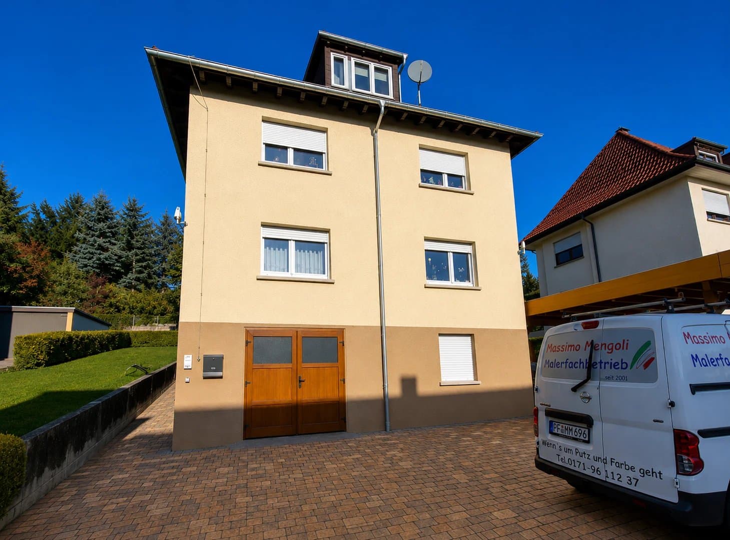 Frisch gestrichenes Einfamilienhaus mit Firmenfahrzeug