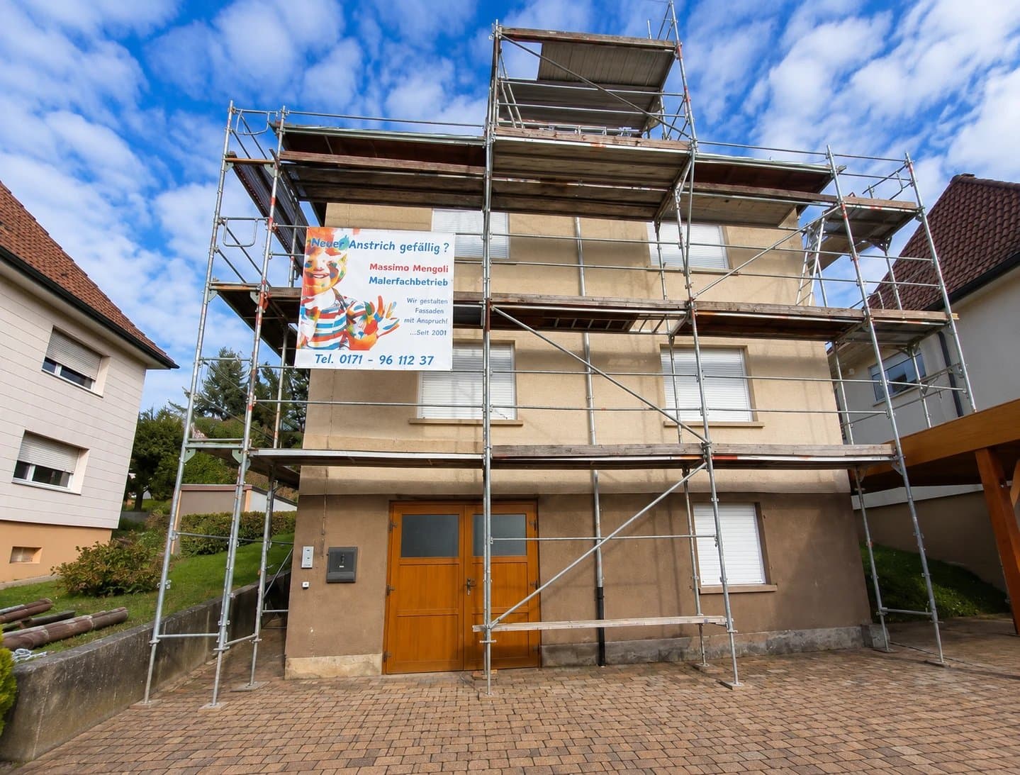 Mehrstöckiges Wohnhaus mit umfangreichem Gerüst während der Fassadensanierung